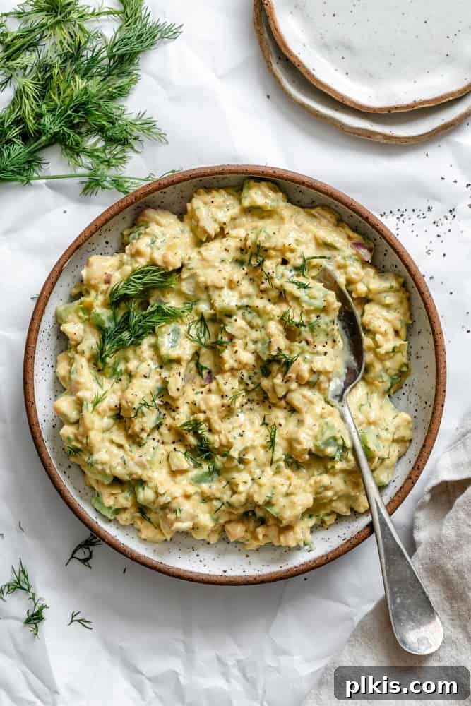 A vibrant bowl of Easy Curried Chickpea Salad, showcasing its rich color and creamy texture, served alongside fresh greens or crackers, ready to be enjoyed as a wholesome, plant-based meal.