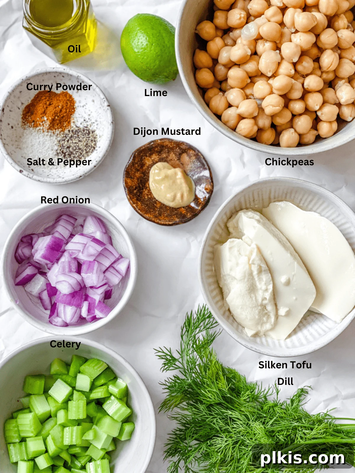 All the fresh and pantry staple ingredients for Easy Curried Chickpea Salad, meticulously measured out and arranged on a clean white surface, highlighting the vibrant colors and readiness for preparation.