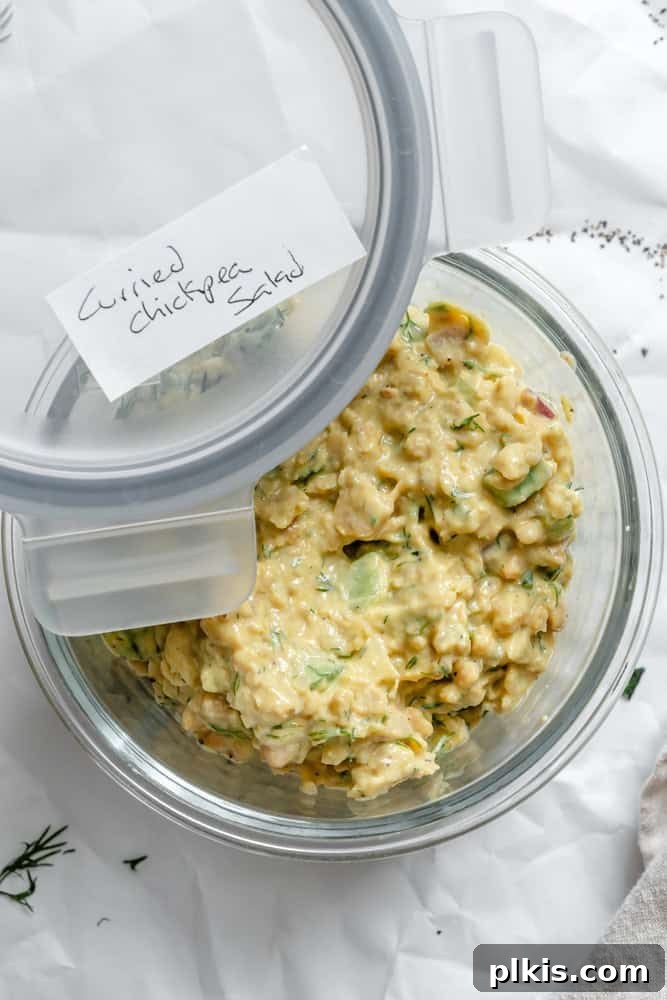 A neatly portioned serving of Easy Curried Chickpea Salad stored in a clear, airtight container, ready for meal prep or refrigeration, ensuring its freshness and convenience for future enjoyment.