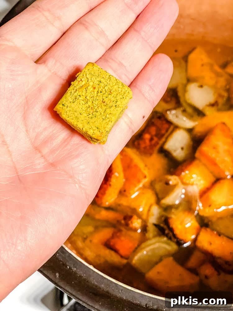 Sweet Autumn Squash and Apple Bisque 5 Process shot of adding vegetable bouillon cube to pot.