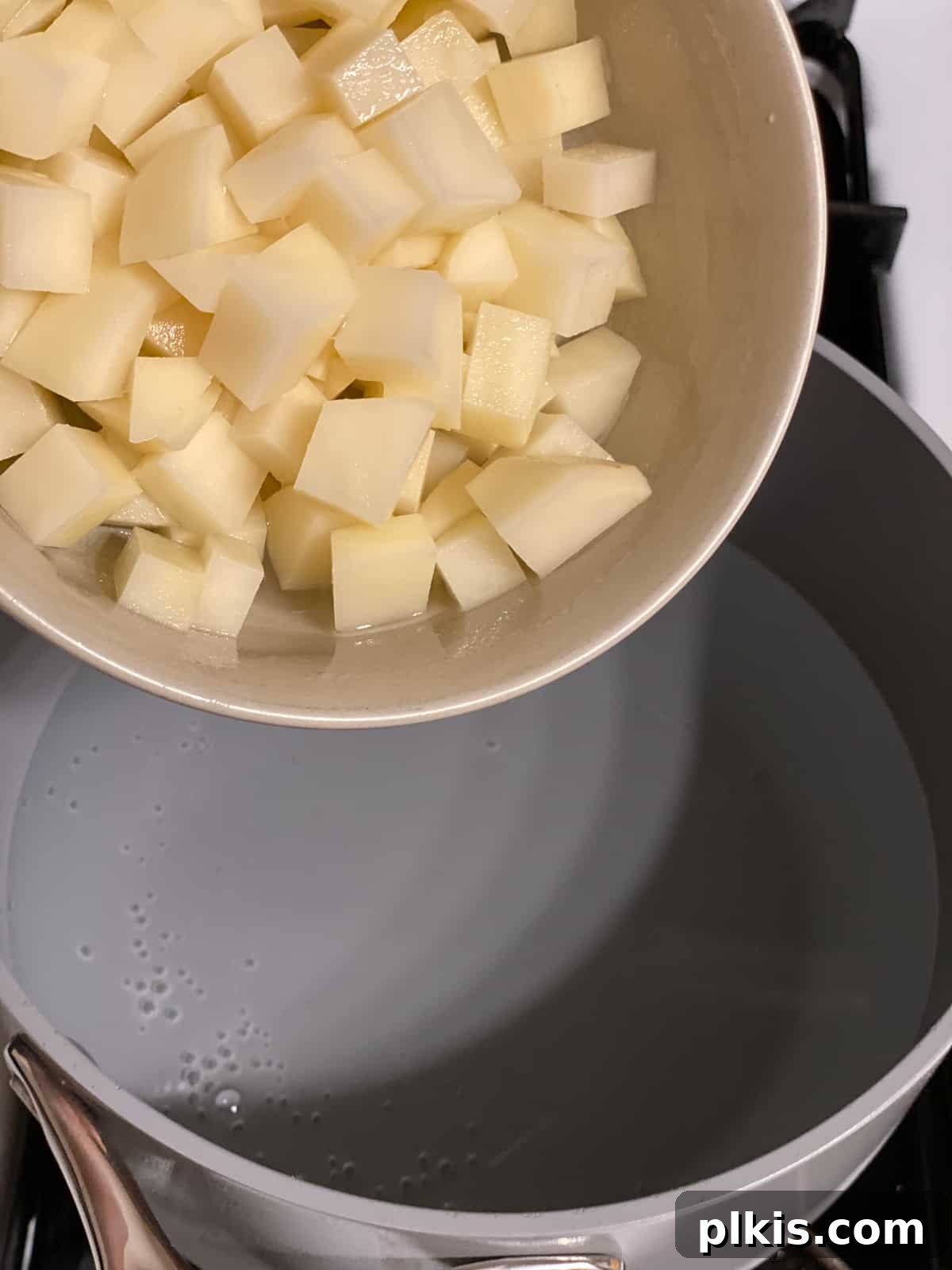 Golden Potato and Chickpea Tacos 6 Process shot of diced potatoes being added to a saucepan filled with water, ready for boiling.