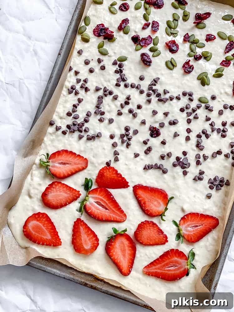 Process shot showing toppings added to batter on sheet pan.