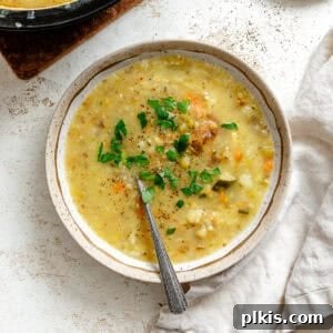 A bowl of creamy Vegan Potato Soup alongside a pot of the finished soup, ready to be served.