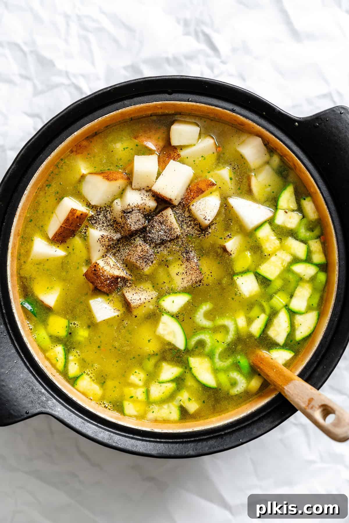 Hearty Vegan Potato and Vegetable Soup 5 Cooked vegetables and potatoes simmering in a large pot with vegetable broth, creating the base for the soup.