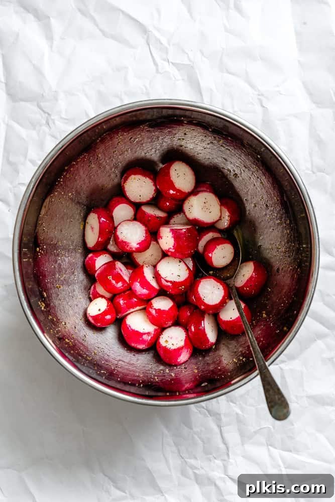 Roasted Radish Revelation 5 Process shot showing washed and trimmed radishes in a bowl, coated with seasoning.