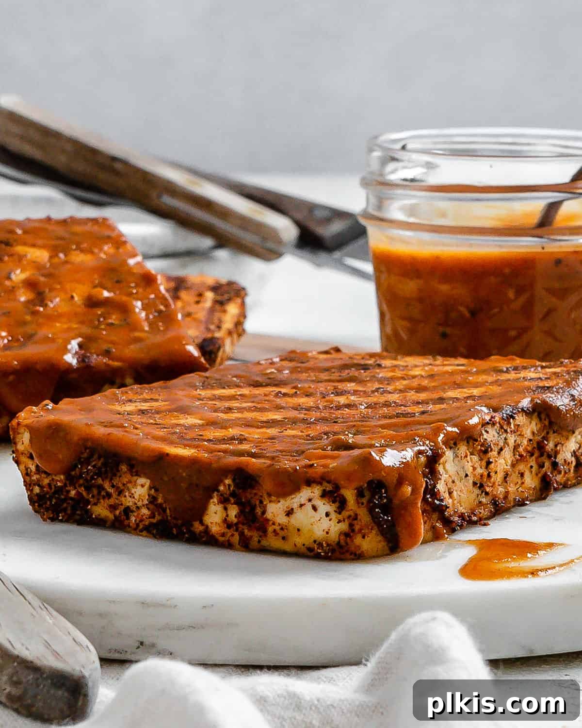 Next-Level Grilled Tofu Steaks 12 A plate of grilled tofu steaks, garnished and ready to be served, showcasing their perfect texture and grill marks