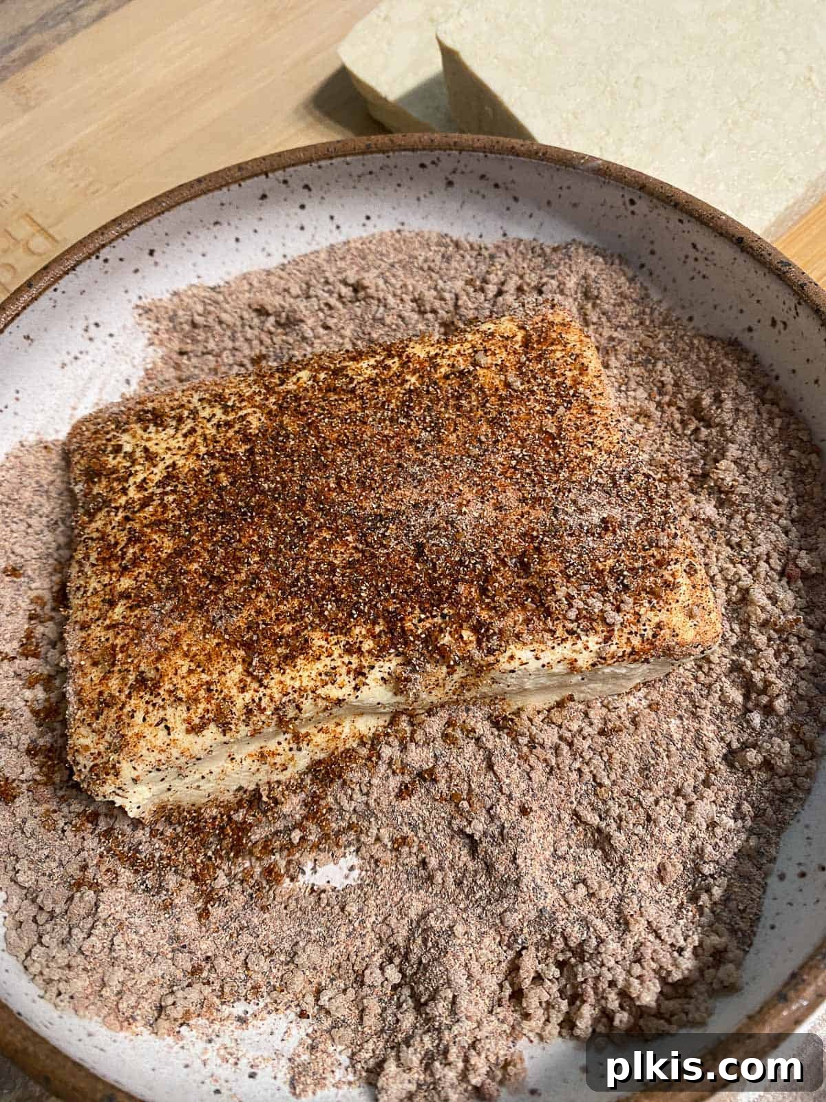 Next-Level Grilled Tofu Steaks 9 Seasoned tofu slice being coated with the spice rub on both sides for maximum flavor infusion