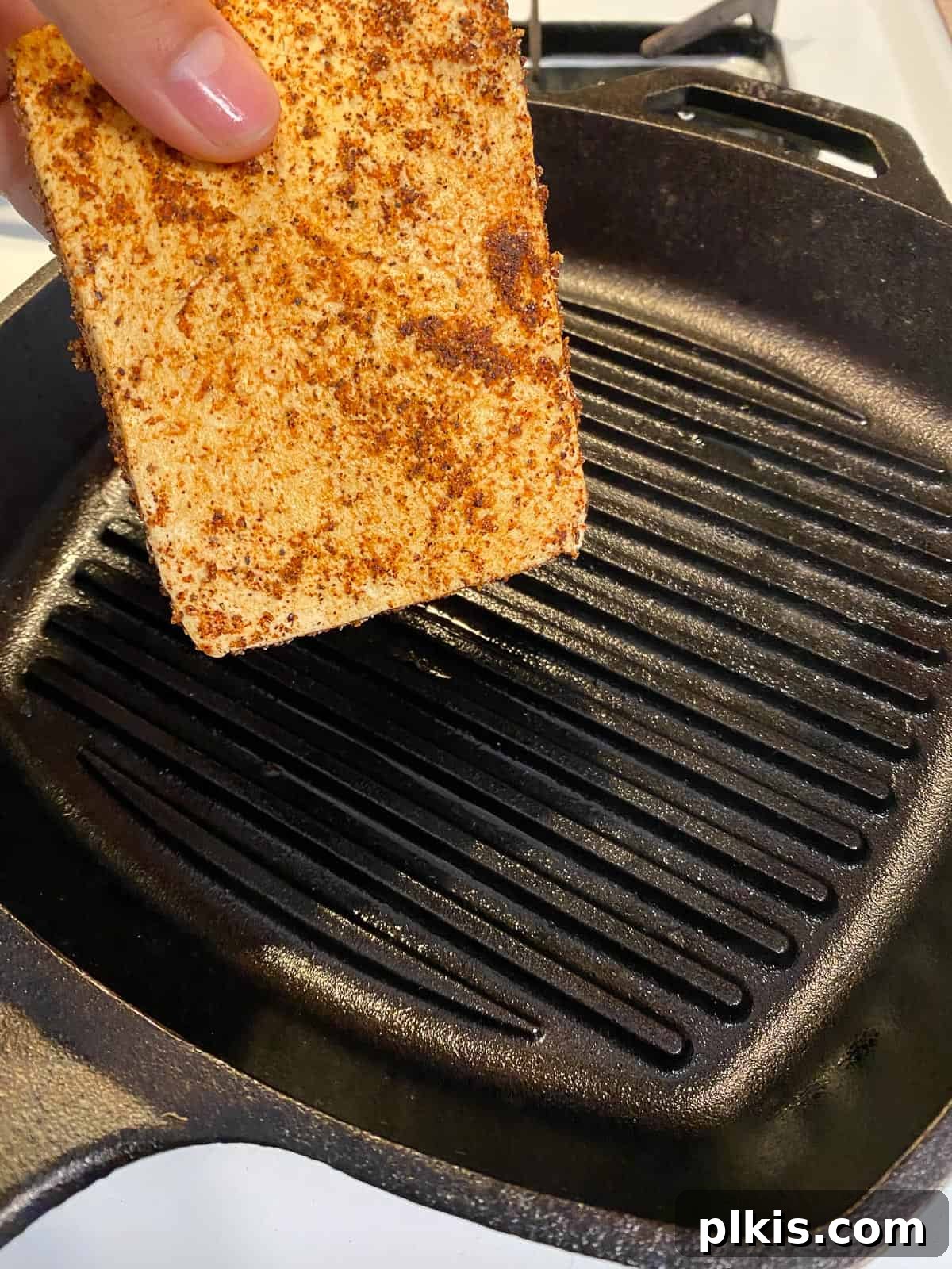 Next-Level Grilled Tofu Steaks 10 Seasoned tofu slices being carefully placed onto a hot grill to cook