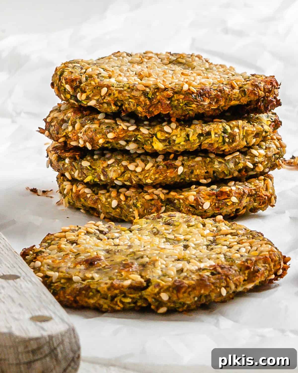 Wholesome Baked Plant-Based Zucchini Fritters 2 completed stack of Vegan Baked Zucchini Fritters against a white surface