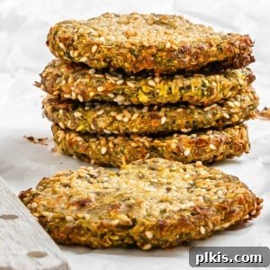 Wholesome Baked Plant-Based Zucchini Fritters 13 completed stack of Vegan Baked Zucchini Fritters against a white surface