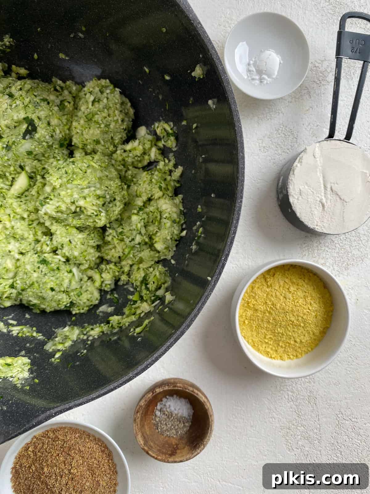 Wholesome Baked Plant-Based Zucchini Fritters 8 post pulsing zucchini mixture in bowl alongside additional ingredients