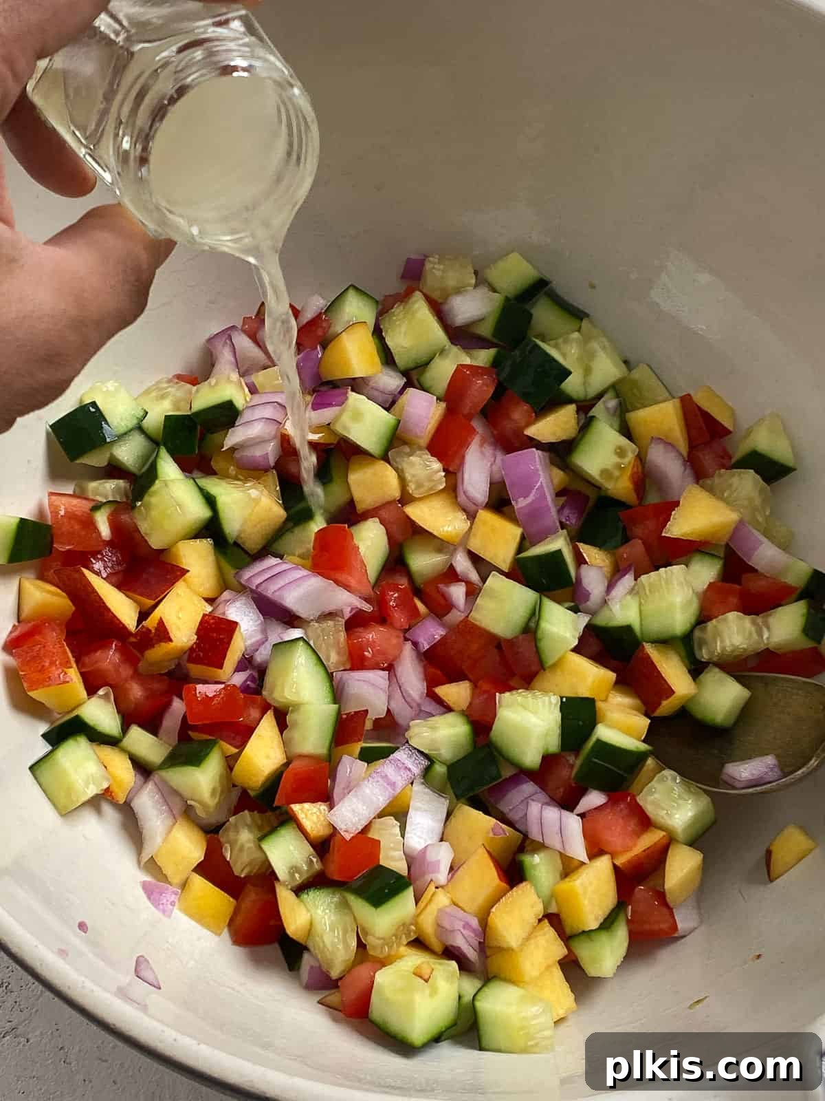 Zesty Fattoush Crunch 5 Lemon juice being added to bowl of veggies