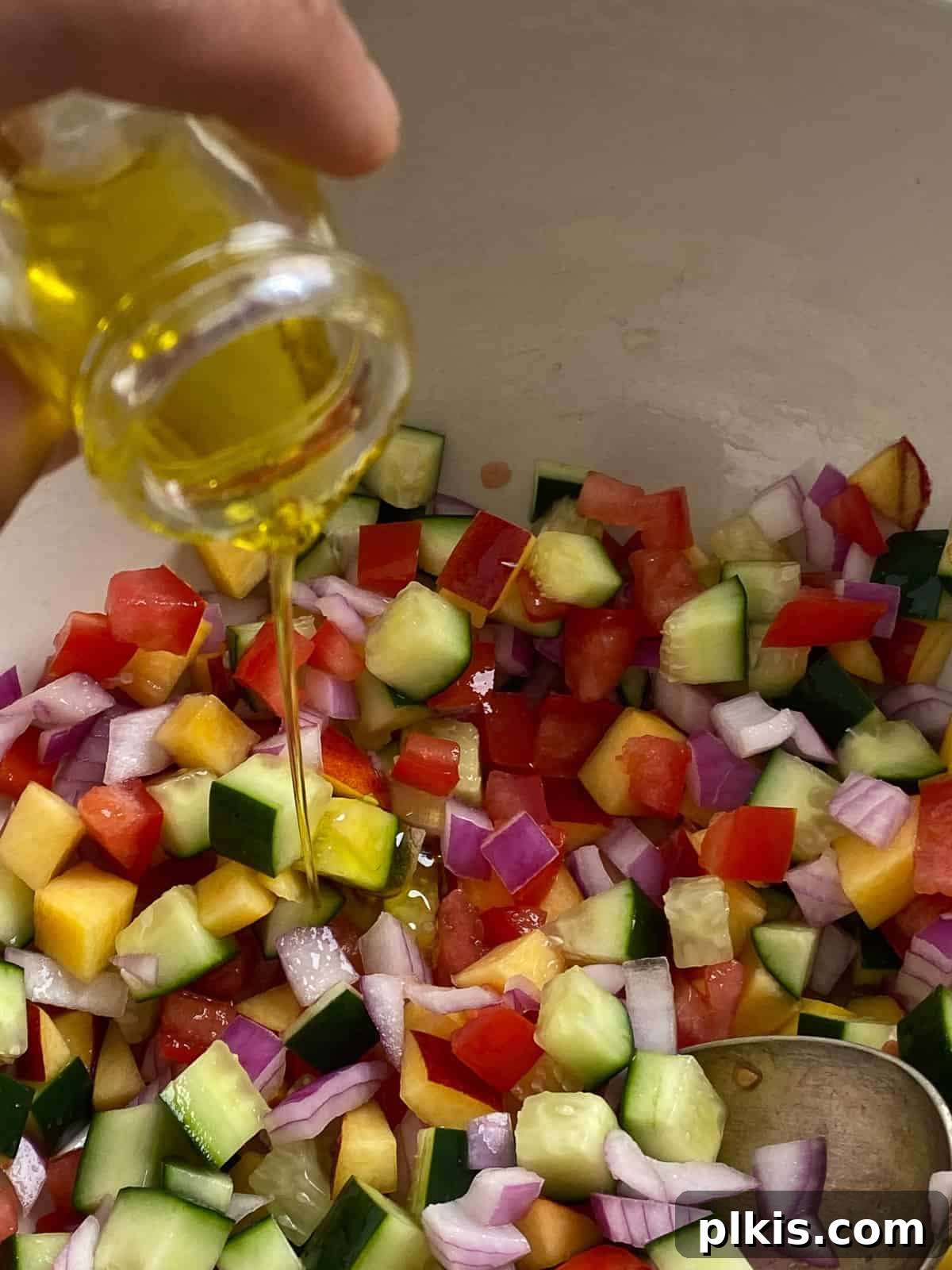 Zesty Fattoush Crunch 6 Olive oil being added to bowl of veggies