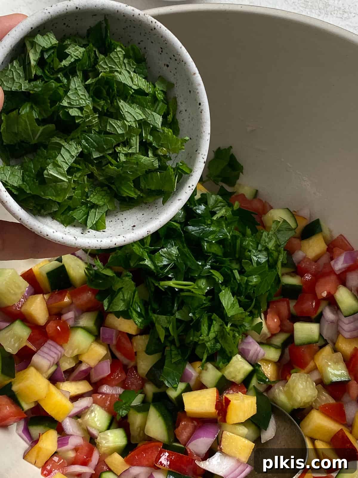 Zesty Fattoush Crunch 7 Parsley being added to bowl of veggies