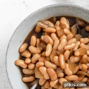 completed Vegan Slow Cooker Baked Beans in a white bowl against a white background