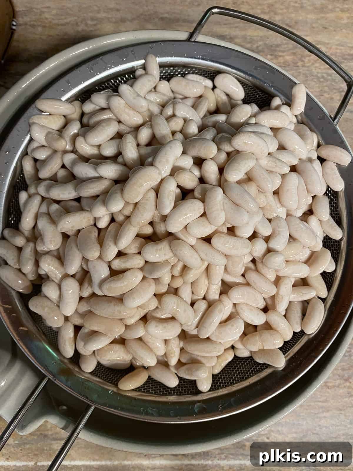 Homestyle Vegan Slow Cooker Baked Beans 6 Process shot of draining water from soaked beans through a colander