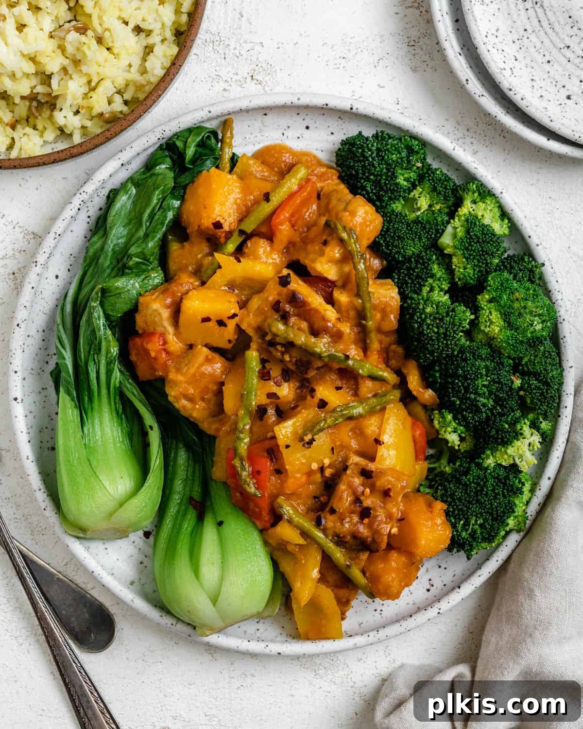 Delicious and vibrant Sweet and Sour Tempeh dish plated against a light background, highlighting its rich colors and textures.