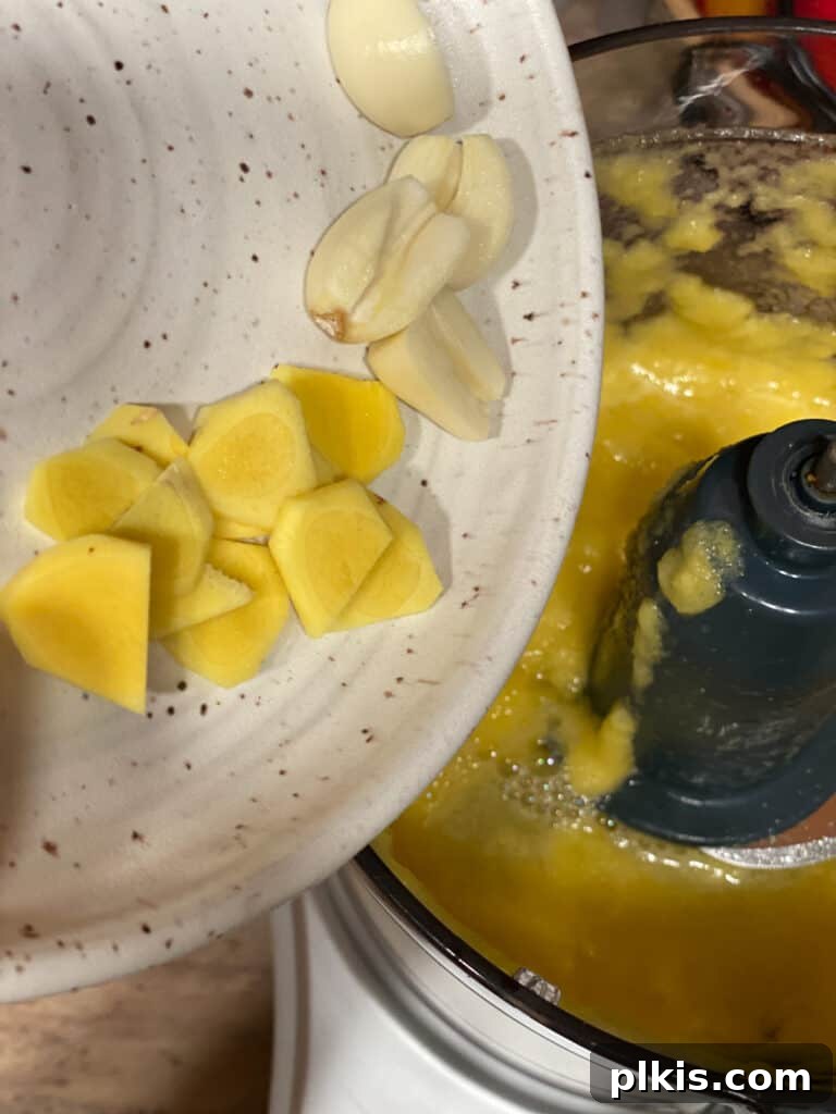 Process shot of adding minced garlic and ginger to the food processor for the sauce.