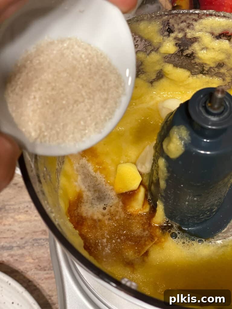 Process shot of adding sugar to the food processor for the sweet and sour sauce.