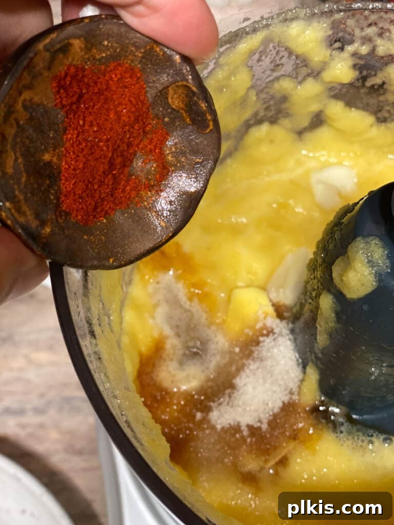 Process shot of adding paprika to the food processor for the sweet and sour sauce, for color and flavor.