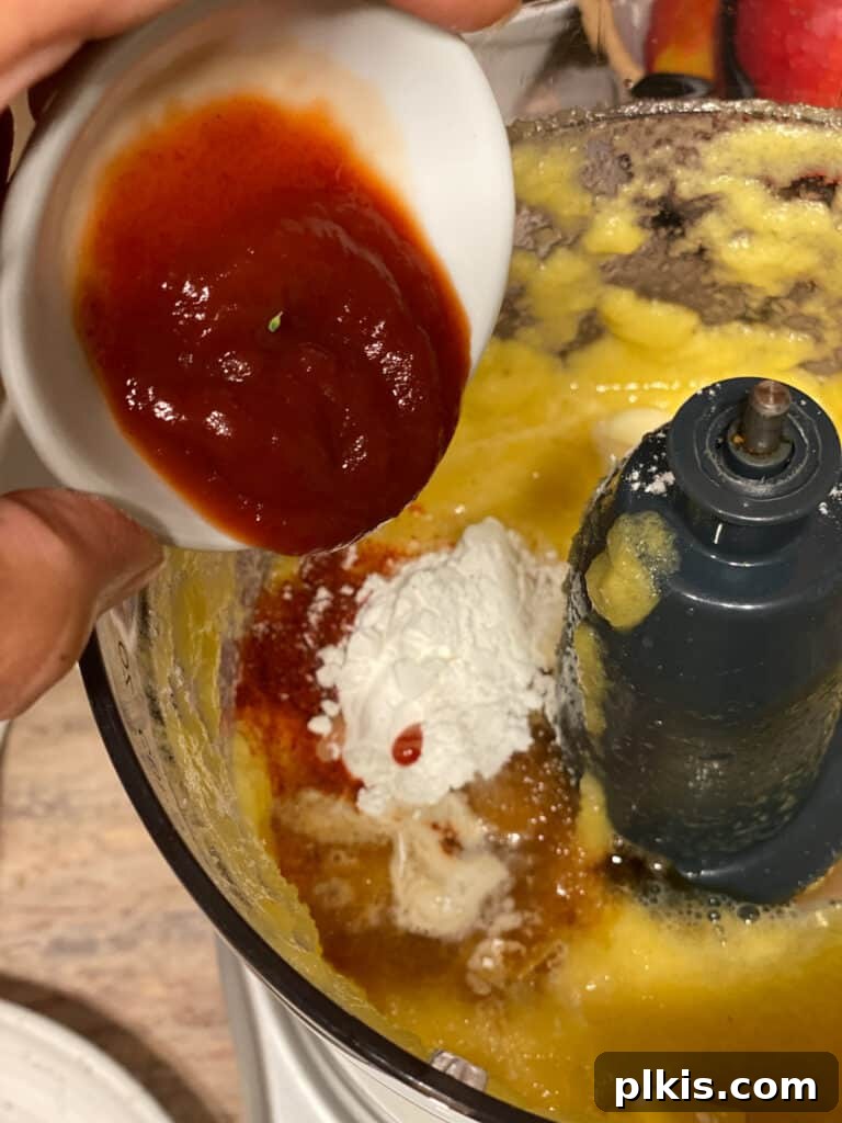 Process shot of adding ketchup to the food processor for the sweet and sour sauce.