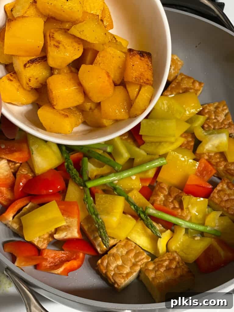 Process shot of adding squash pieces to the pan, completing the vegetable medley.