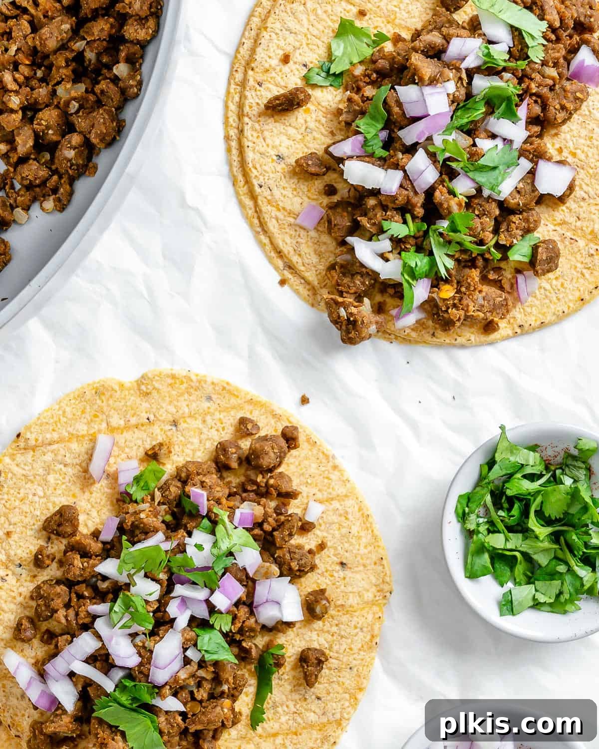 Hearty Plant-Based Lentil Street Tacos 2 completed Plant Based Street Tacos with Lentils on a white surface with ingredients in the background