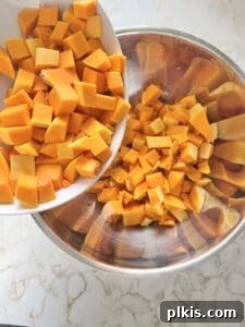 Curried Butternut Squash Roast 4 Step 1: Raw butternut squash being peeled with a knife