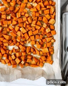 Curried Butternut Squash Roast 9 Process photo showing perfectly cooked roasted butternut squash cubes on a baking sheet
