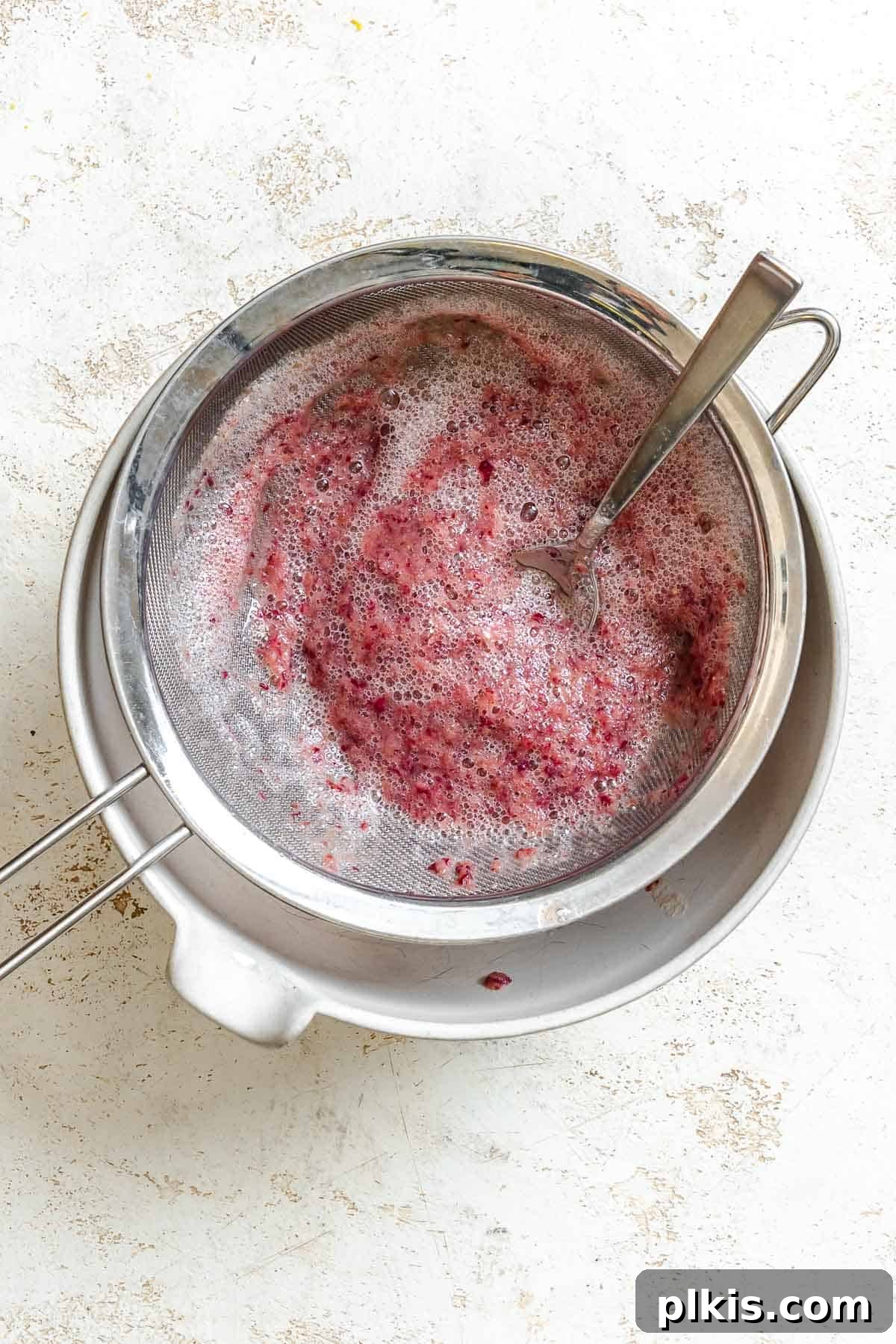 Ruby or Jade Grape Sorbet 5 Process shot showing using a fine-mesh sieve for the blended grapes.