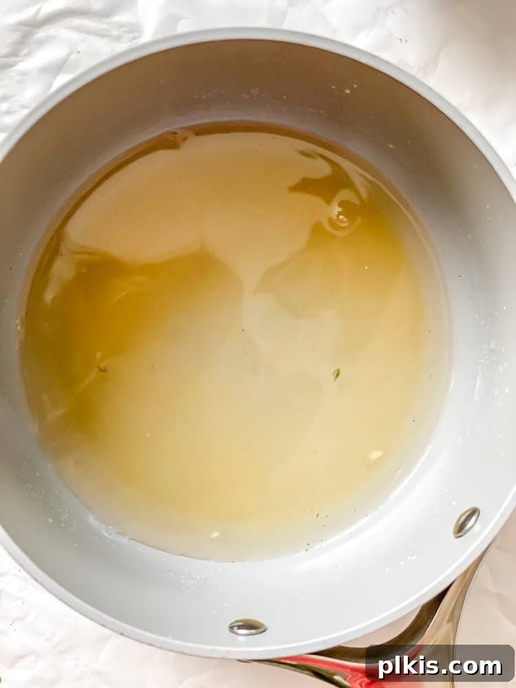 Crisp Cucumber Dill Delight 6 A saucepan on a stovetop containing the clear vinegar marinade mixture, gently heating.