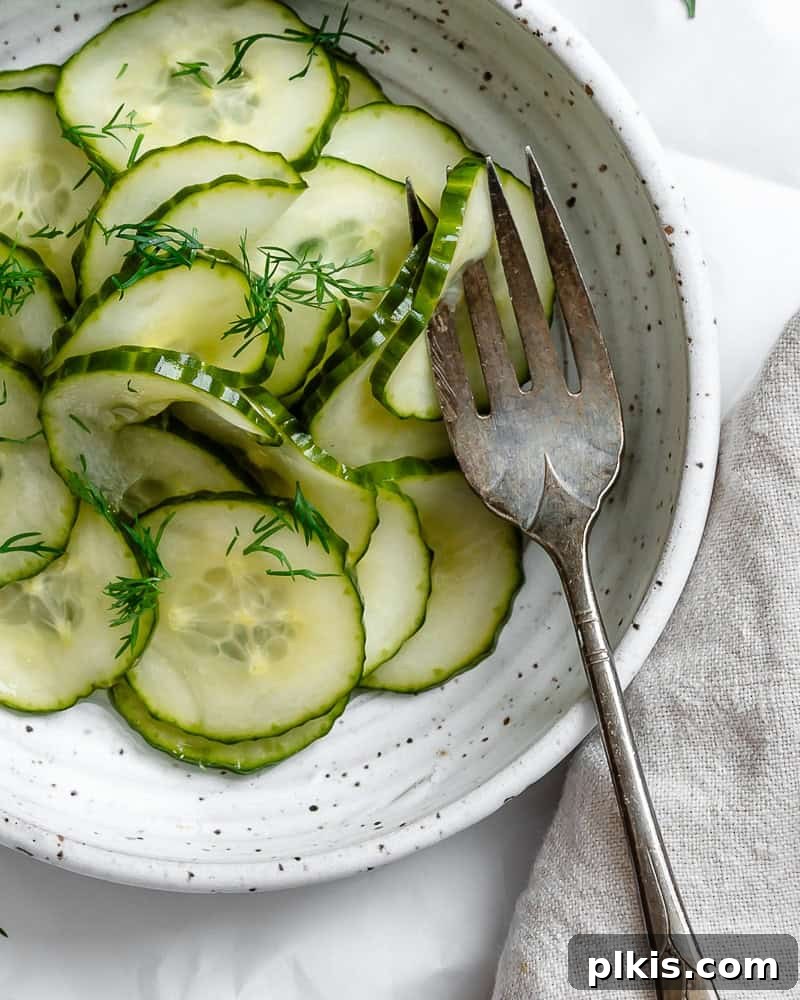 Crisp Cucumber Dill Delight 10 A pristine white bowl filled with crisp cucumber dill salad, garnished with fresh dill and ready for serving.