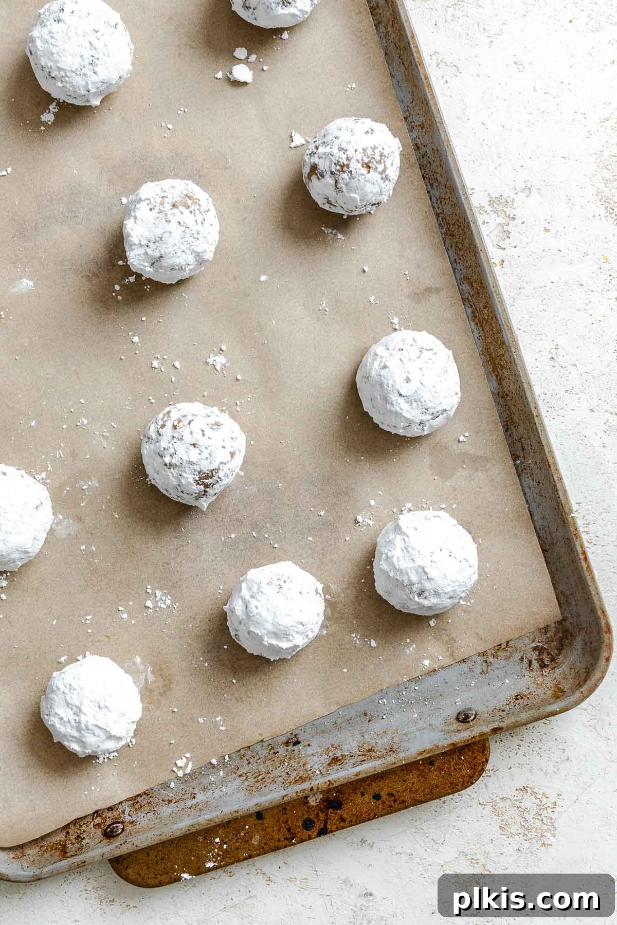 Festive Eggless Gingerbread Crinkle Cookies 9 Process shot showing pre-baked gingerbread crinkle cookies neatly arranged on a parchment-lined baking sheet.