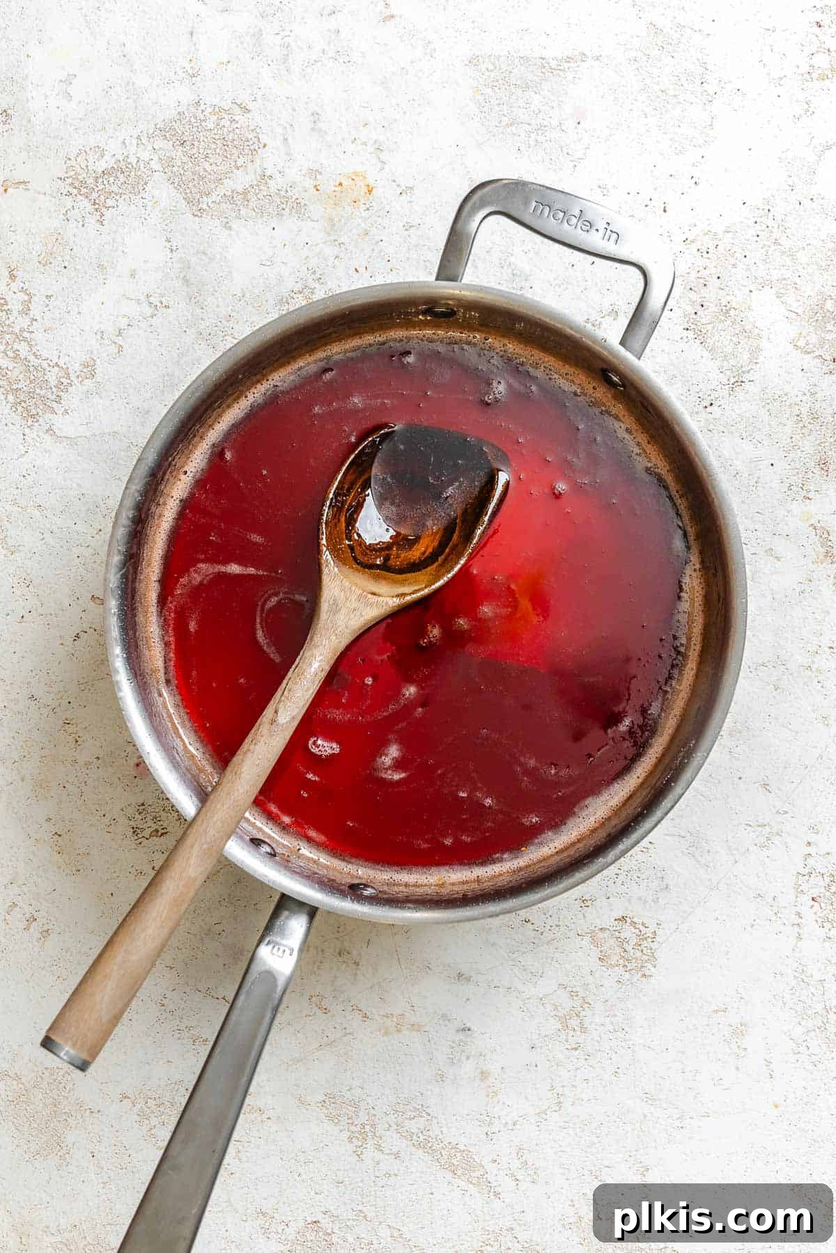 Effortless Pectin-Free Grape Jam 6 Process shot showing stirring ingredients in a pot.