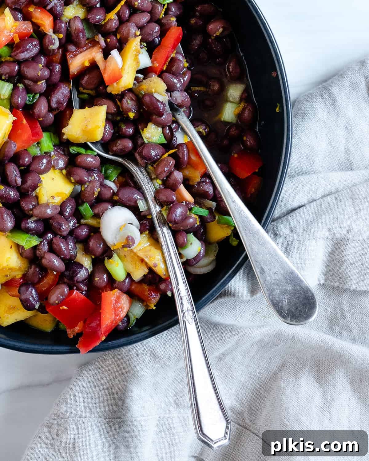 A close-up shot of the finished mango black bean salad, highlighting the vibrant colors and textures of the ingredients.