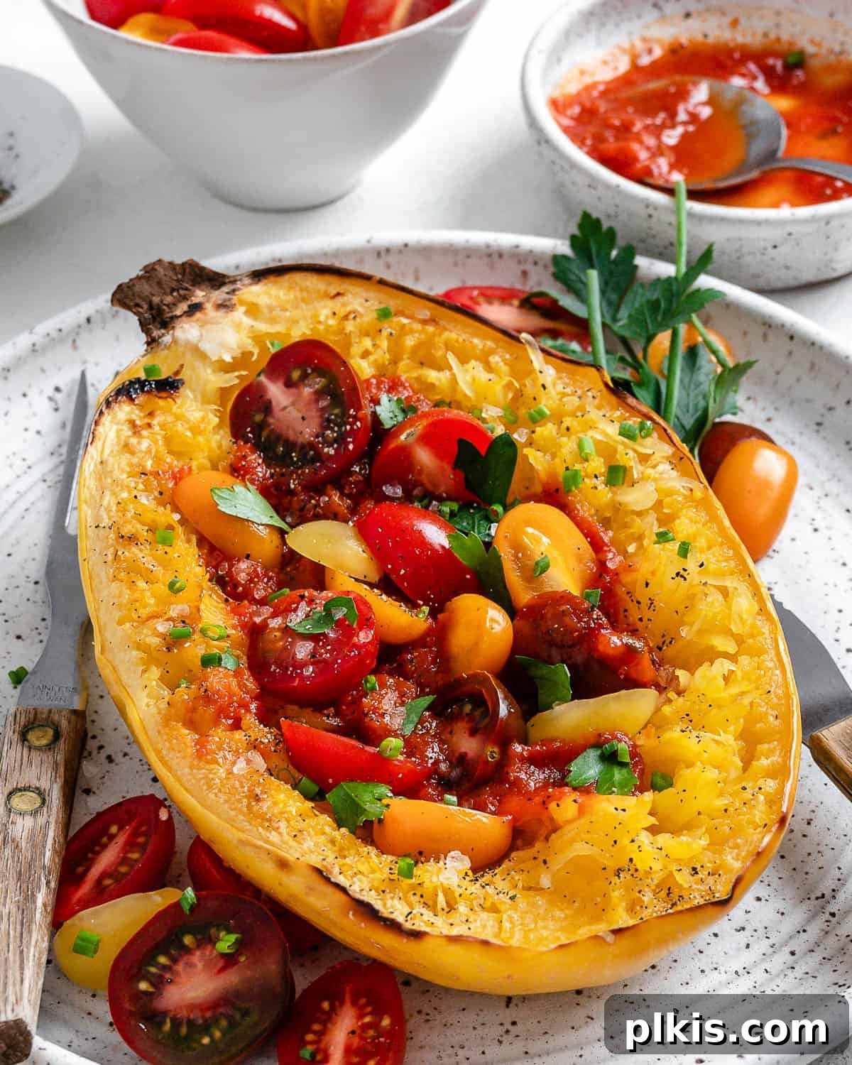 The Secret to Delicious Baked Spaghetti Squash 7 A vibrant bowl of roasted spaghetti squash topped with marinara sauce, fresh grape tomatoes, and chives, ready to be served as a healthy, low-carb meal.