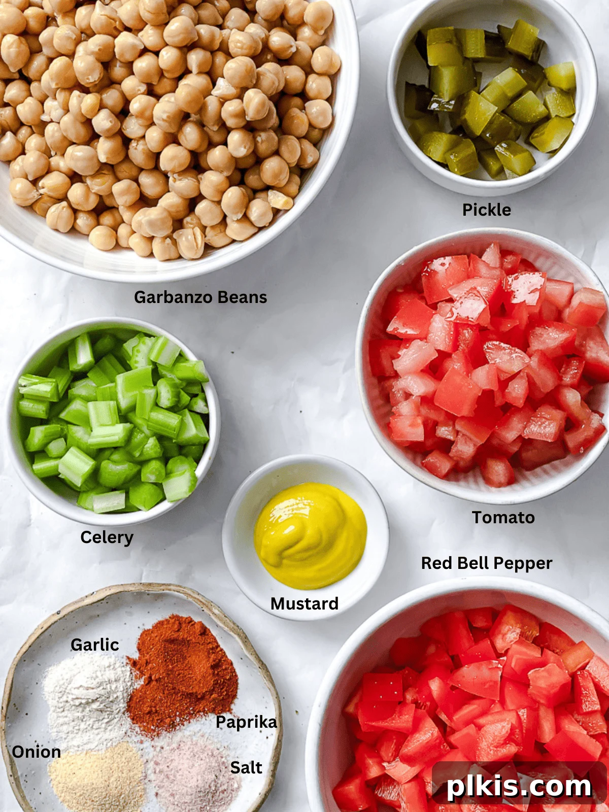 Vibrant Vegan Chickpea Salad 3 A collection of fresh ingredients for vegan garbanzo bean salad, meticulously arranged in small white bowls with clear labels, showcasing vibrant colors and textures.