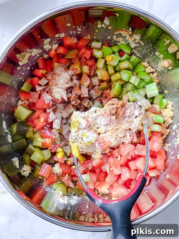 Vibrant Vegan Chickpea Salad 6 Process shot illustrating all ingredients, including mashed chickpeas, diced vegetables, and seasonings, combined together in a bowl and thoroughly mixed.