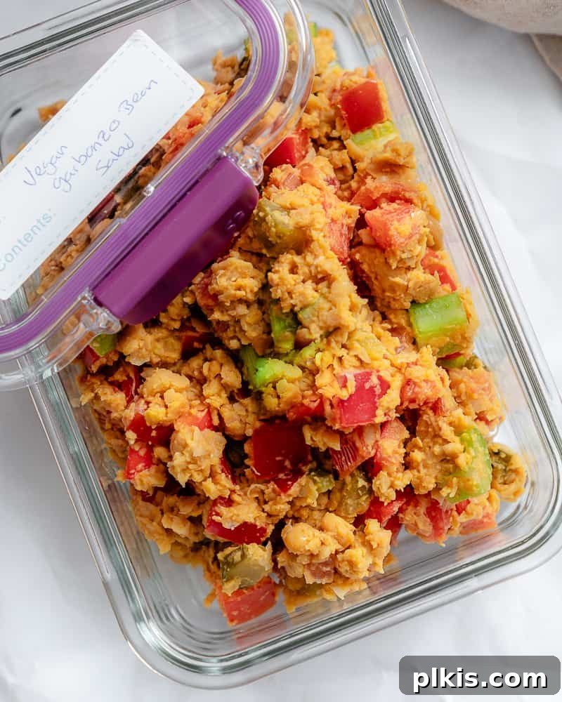 Vibrant Vegan Chickpea Salad 8 Vegan garbanzo bean salad neatly packed in a glass container with a lid, ready for meal prep, with a label reading "vegan garbanzo bean salad".