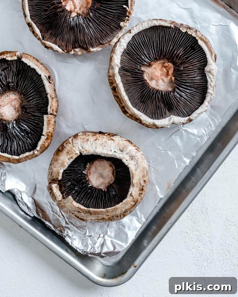 Portobello Pizza Caps 4 portobello mushrooms on a baking tray lined with parchment paper