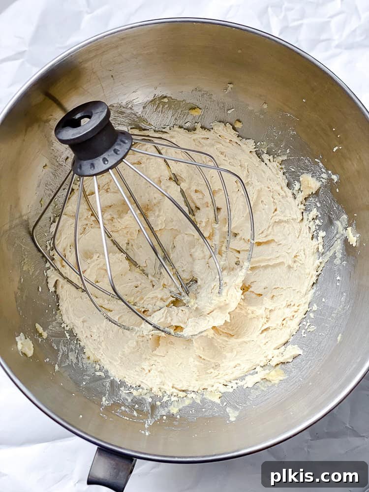 Spiced Pumpkin Oatmeal Cookies 4 Process shot showing wet ingredients being mixed together in a large bowl with an electric mixer, creating a smooth, creamy mixture.