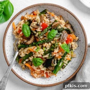 completed vegan risotto plated on a white plate against a white background
