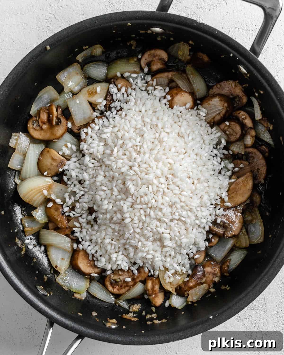 Creamy Vegan Garden Risotto 5 process of adding rice to black skillet