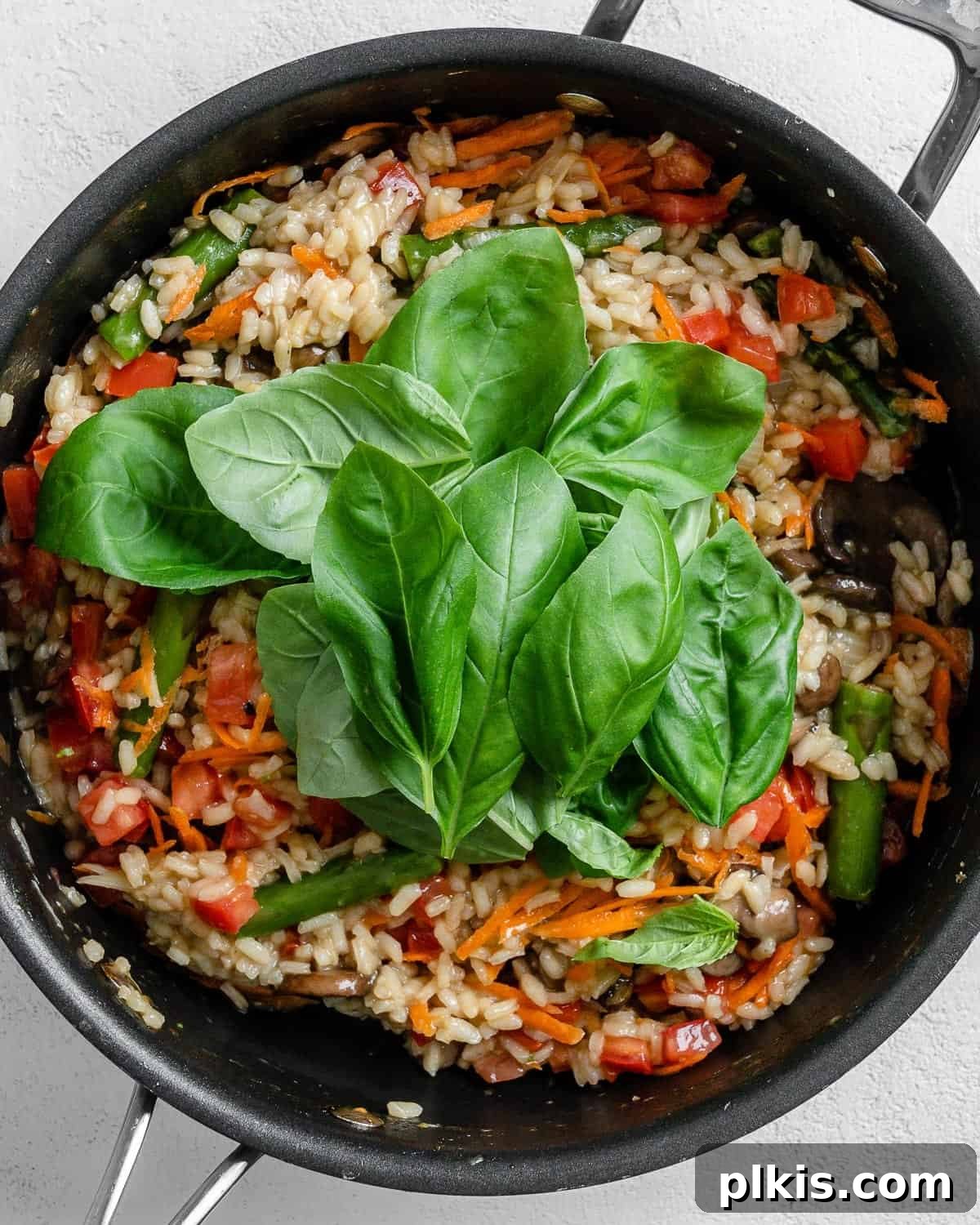 Creamy Vegan Garden Risotto 8 process of basil being added to black skillet