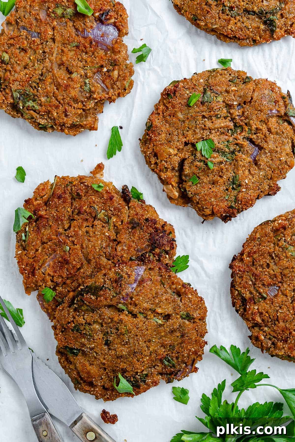 Wholesome Red Lentil Burgers 2 Completed Easy Red Lentil Patties spread out on a white surface, showcasing their golden-brown crispiness.