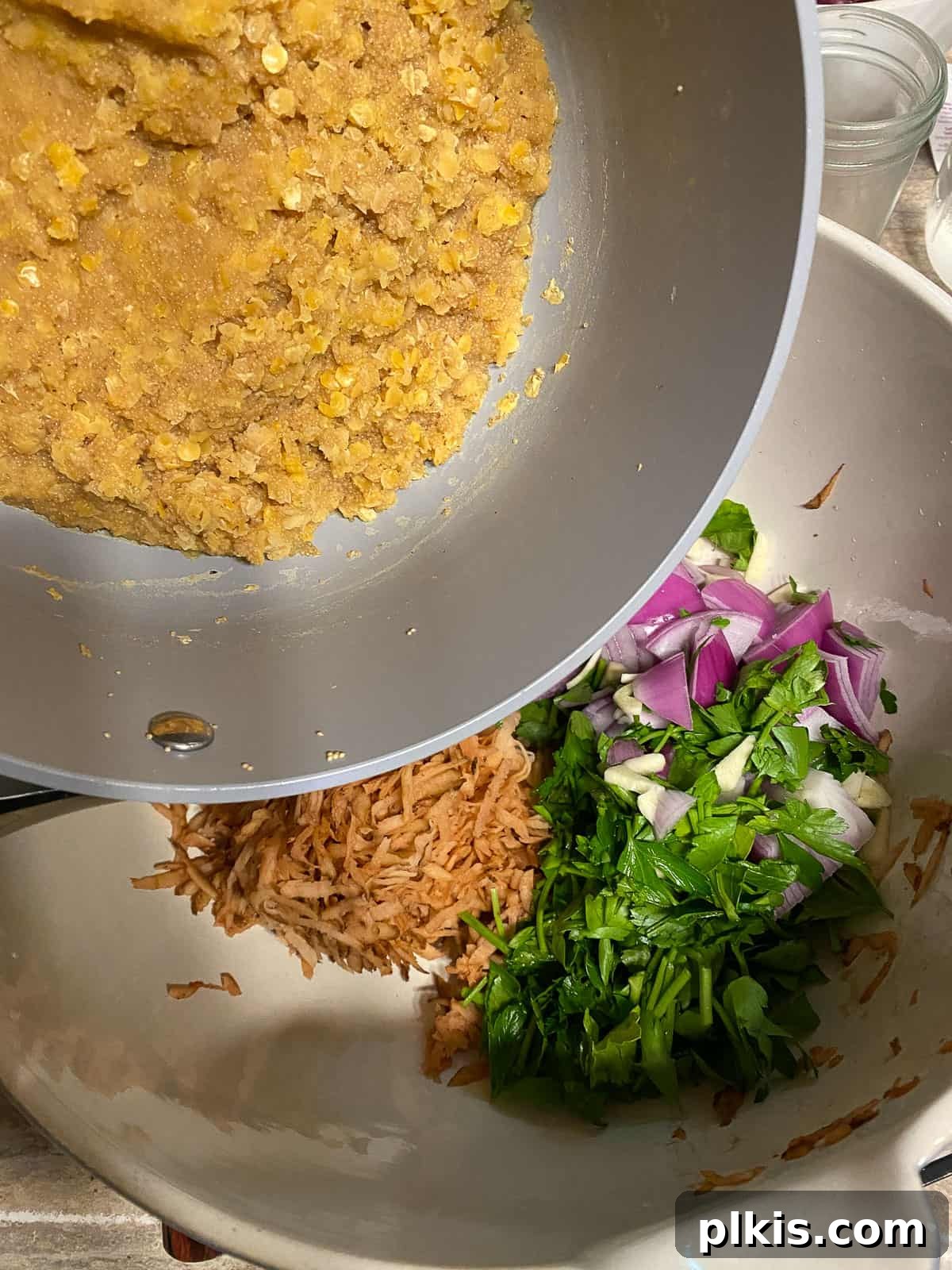 Wholesome Red Lentil Burgers 12 Process shot of adding the cooked lentil and amaranth mixture to the vegetable bowl.
