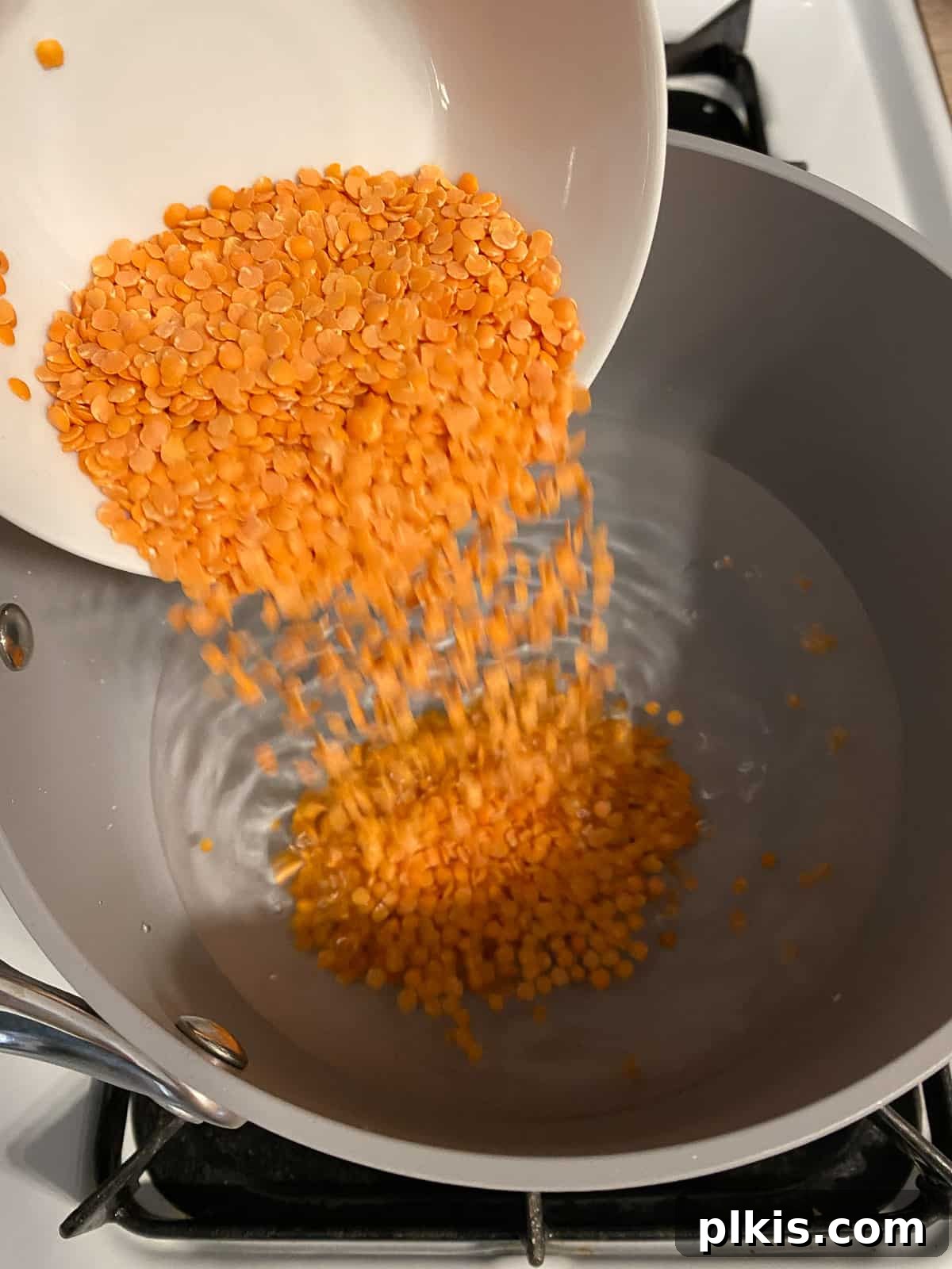 Wholesome Red Lentil Burgers 5 Process shot of adding amaranth to a bowl, highlighting the initial ingredients for the patty base.