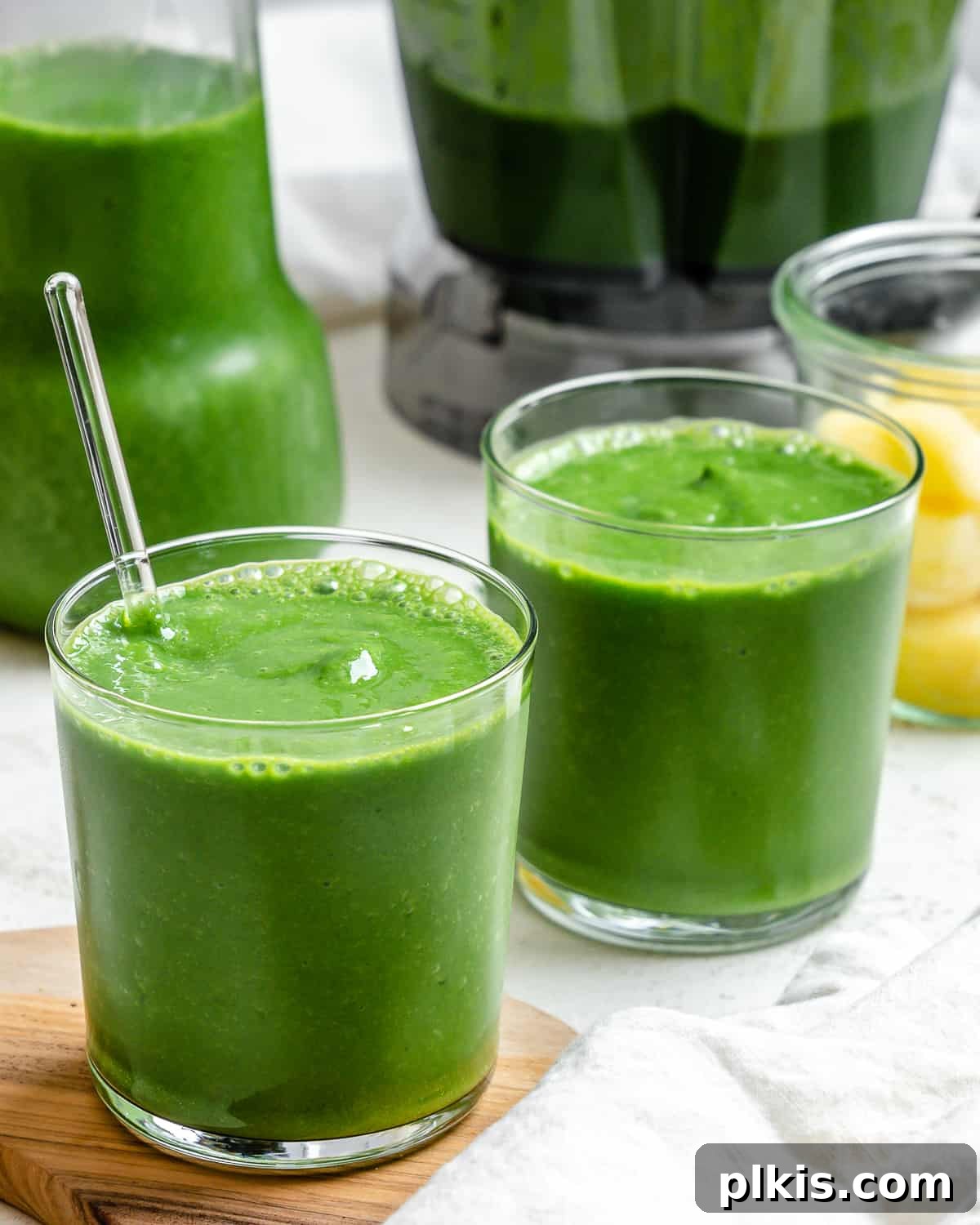 Emerald Pineapple Splash 2 Two glasses of vibrant Kale Pineapple Smoothie, garnished and ready to drink.
