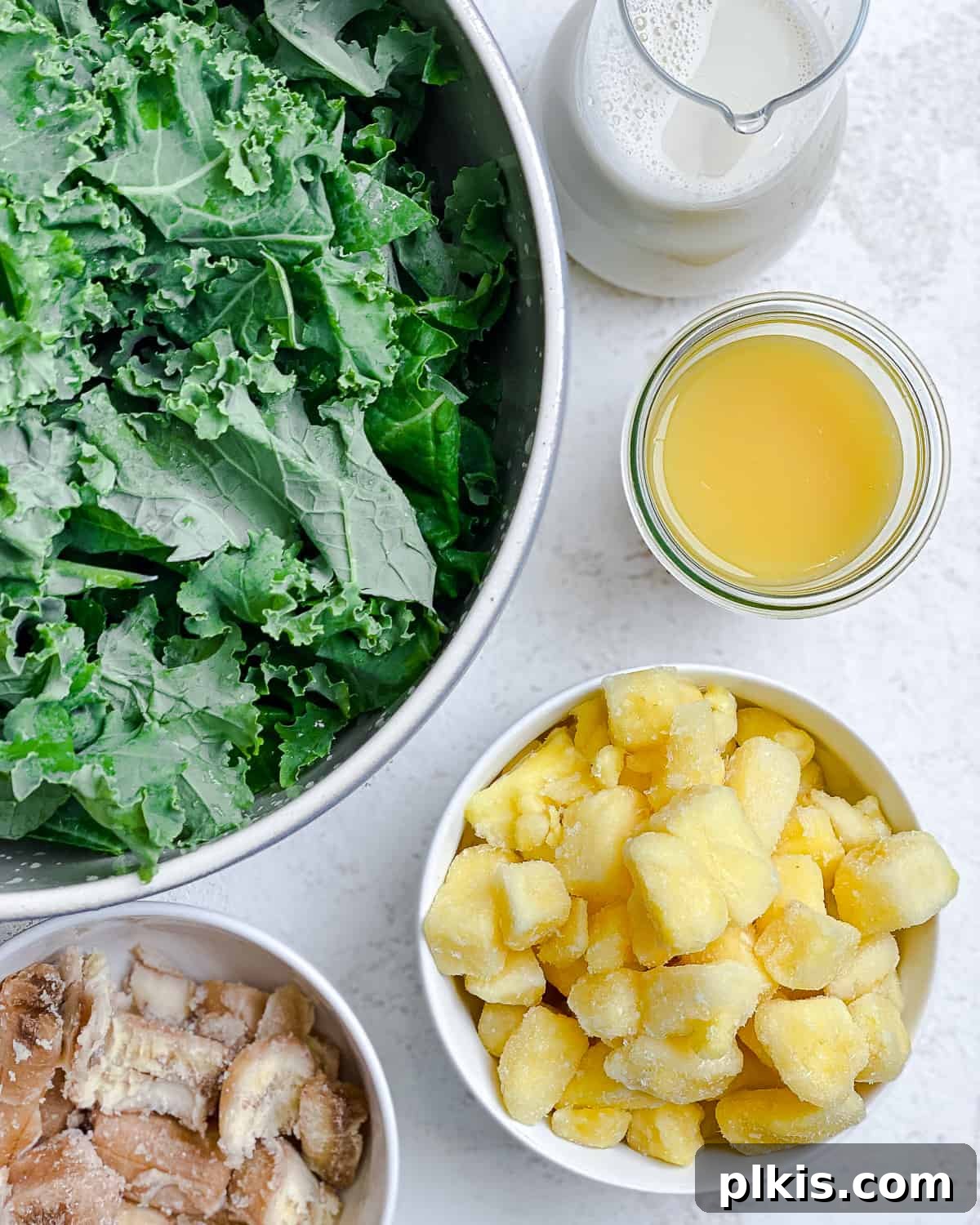 Emerald Pineapple Splash 3 Ingredients for Kale Pineapple Smoothie measured out against a white surface, ready for blending.