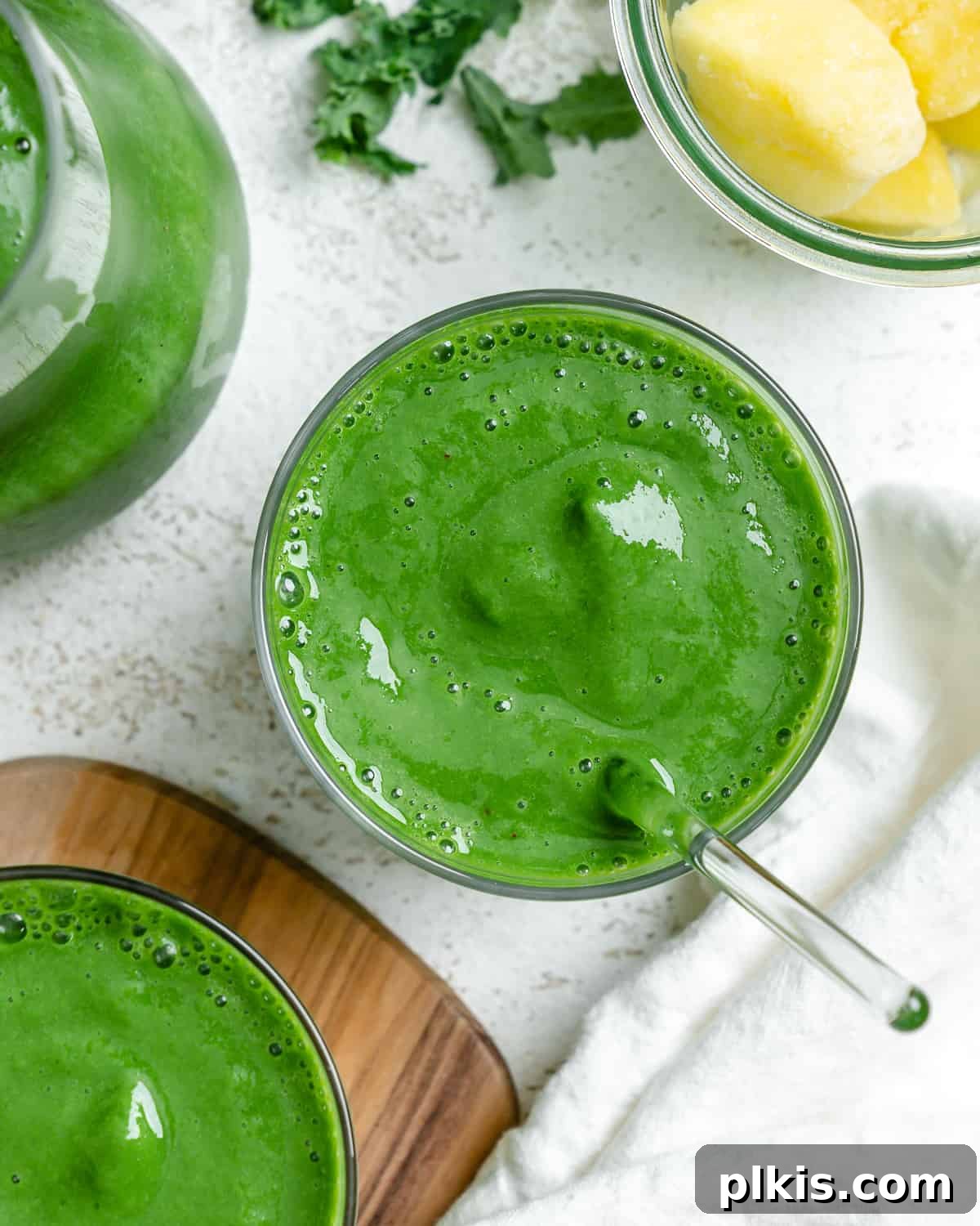 Emerald Pineapple Splash 9 Two glasses of completed Kale Pineapple Smoothie, showcasing its vibrant green color.